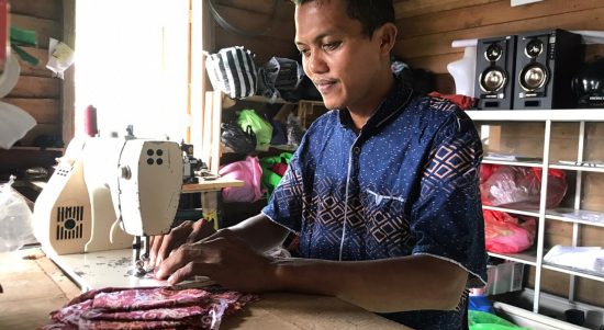 Ahmad Romeli sedang menjahit
