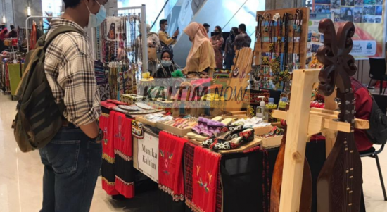 Salah satu pengunjung yang sedang melihat kerajinan khas Kalimantan Timur.