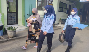 Foto : AV bersama sang bayi saat dikawal oleh petugas kembali ke rutan. Sumber Foto : Istimewa. Foto : AV bersama sang bayi saat dikawal oleh petugas kembali ke rutan. Sumber Foto : Istimewa.
