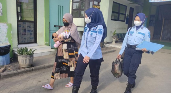 Foto : AV bersama sang bayi saat dikawal oleh petugas kembali ke rutan. Sumber Foto : Istimewa.