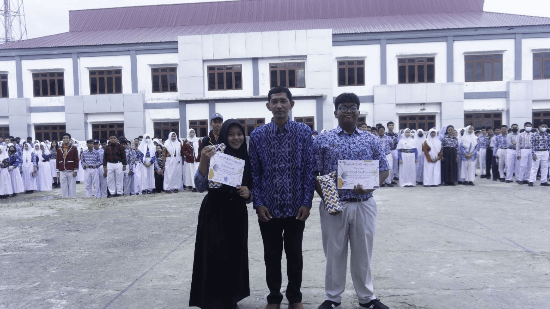 Foto : Ketua Musyawarah Kerja Kepala Sekolah (MKKS) SMA Samarinda, Abdul Rozak (tengah) bersama dengan dua murid SMA N 16 Samarinda. Sumber : Kaltimnow.id