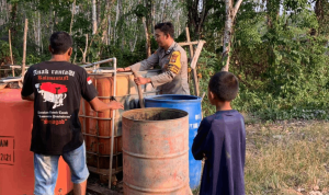 Foto : Polsek Batu Sopang Menyalurkan Air Bersih di Desa Samurangau. Sumber : Kaltimnow.id