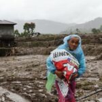 Foto: Seorang warga sedang membawa barang-barang akibat bencana banjir bandang, di Sumatra. Sumber: Istimewa.